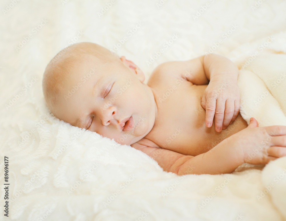 Cute baby sleeps on side on the bed at home Cute baby sleeps on side on the bed at home