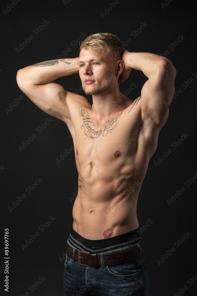 Junger Mann mit Muskeln und Tattoos