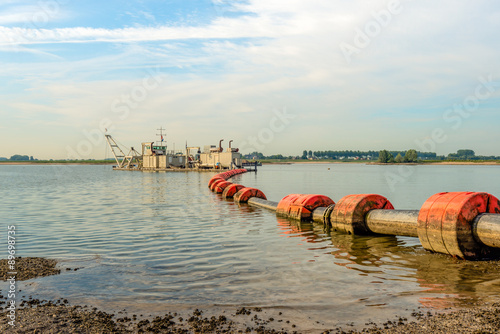 Floating suction dredge in the river photo