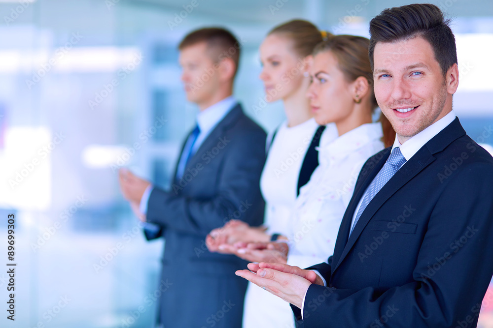 Smiling business people applauding a good presentation in the Smiling business people applauding a good presentation in the