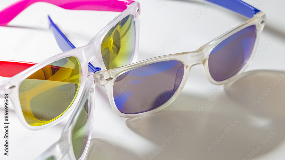Many sunglasses isolated on a white background with dark shadow silhouettes