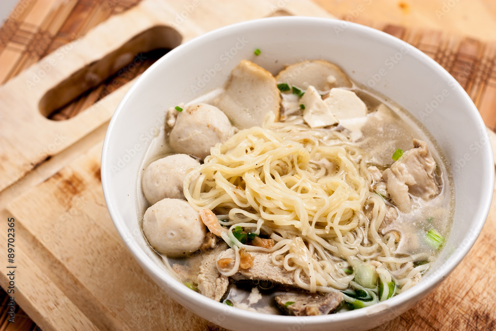 Rice Noodles Bone Soup with Meat Balls and Fish Balls on wood background,Thai food. Rice Noodles Bone Soup with Meat Balls and Fish Balls on wood background,Thai food.