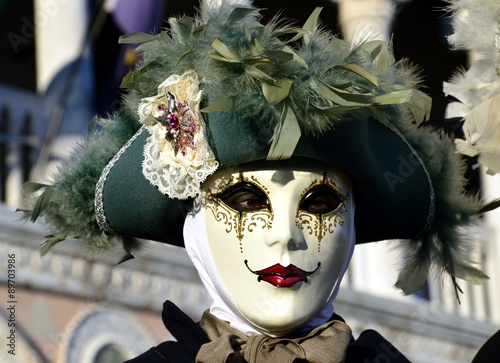 Painted mask with green feathered hat during the Carnival of Venice, Italy photo