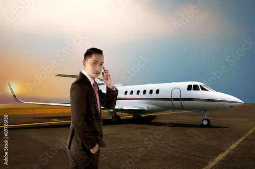 Young business man calling by phone when walking to the plane