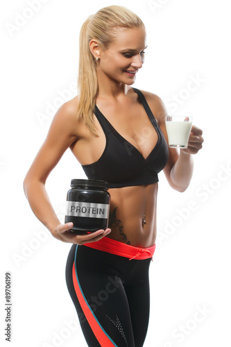 Athletic beautiful smiling blonde woman with proteine and glass