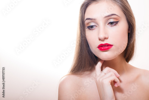 Cropped portrait of young sensual lady with finger on her chin 