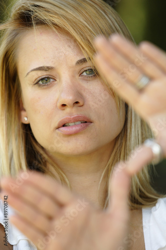 Woman framing face with hands. Focus is on her lips.