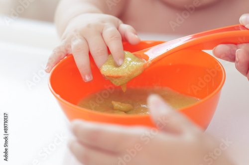 Madre dando de comer a hija puré