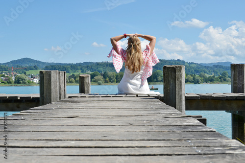 Girl on the wooden jetty at a lake. Switzerland © HappyAlex