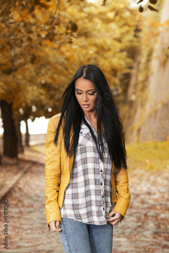 Beautiful dark-haired woman in a yellow leather jacket