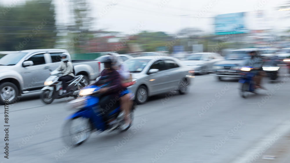 car and motorcycle driving on road with traffic jam in the city, abstract blurred