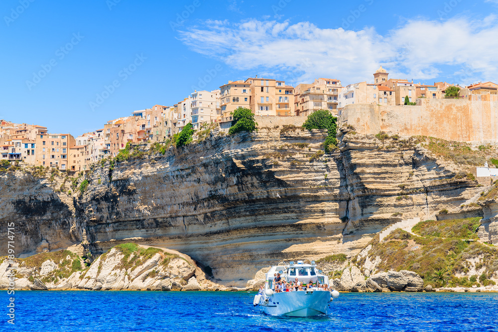 Tourist boat sailing on blue sea on its on daily cruise from Bonifacio port, Corsica island, France