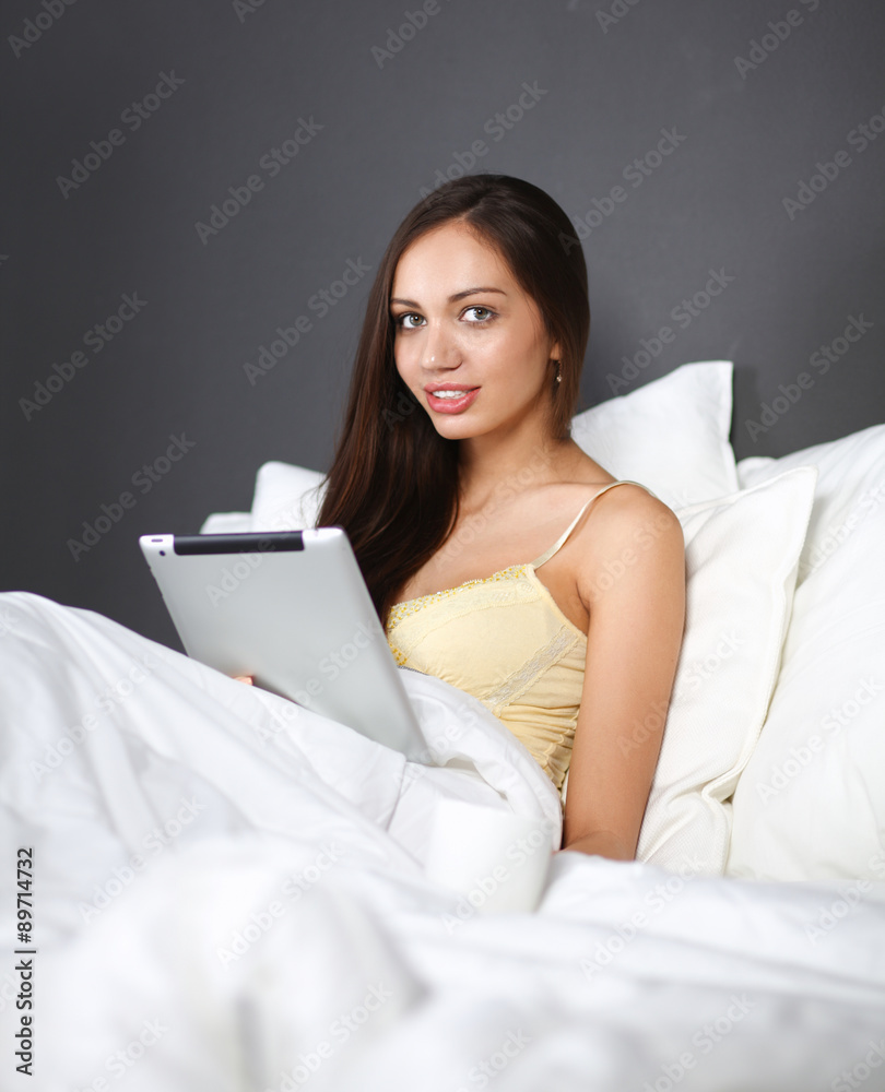 Women use a tablet pc on the bed Women use a tablet pc on the bed