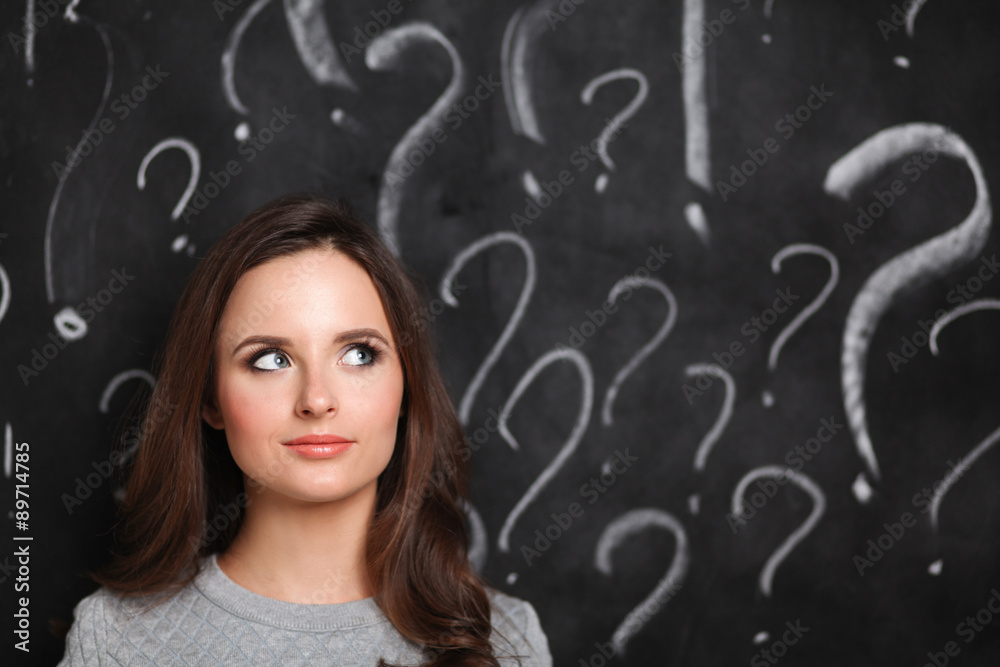 Young girl with question mark on a gray background Young girl with question mark on a gray background