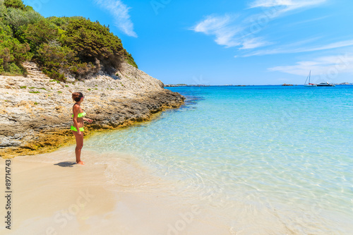 Unidentified attractive young woman in swimsuit standing on beautiful Petit Sperone beach on Corsica island, France © pkazmierczak