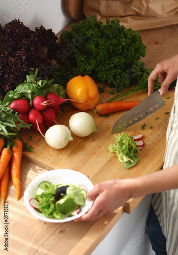 Young woman cutting vegetables in the kitchen