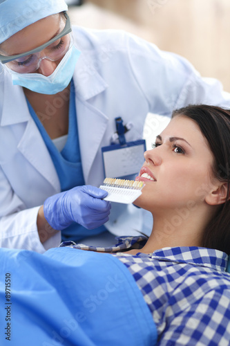 Woman dentist working at her patients teeth