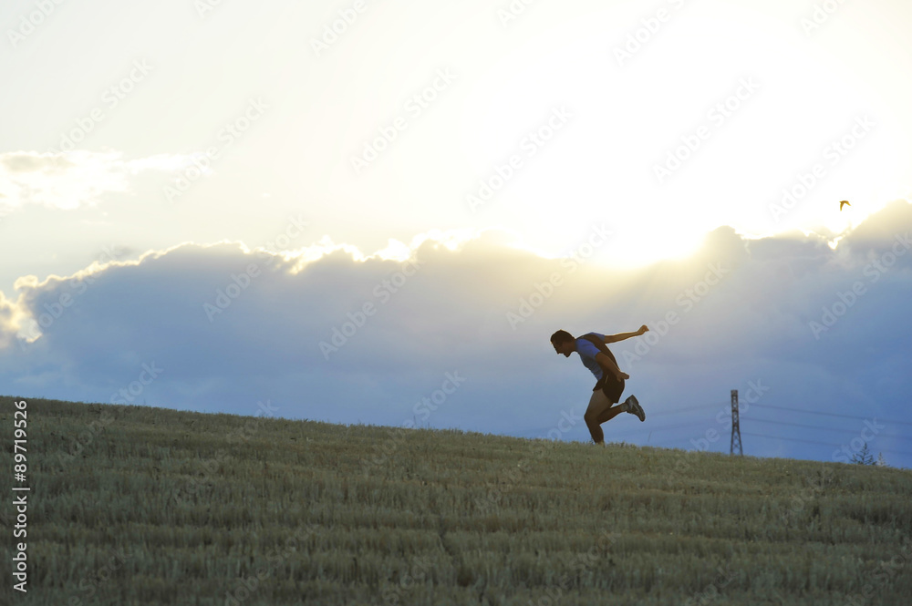 profile silhouette of young man running in countryside practicing final sprint on sunset profile silhouette of young man running in countryside practicing final sprint on sunset