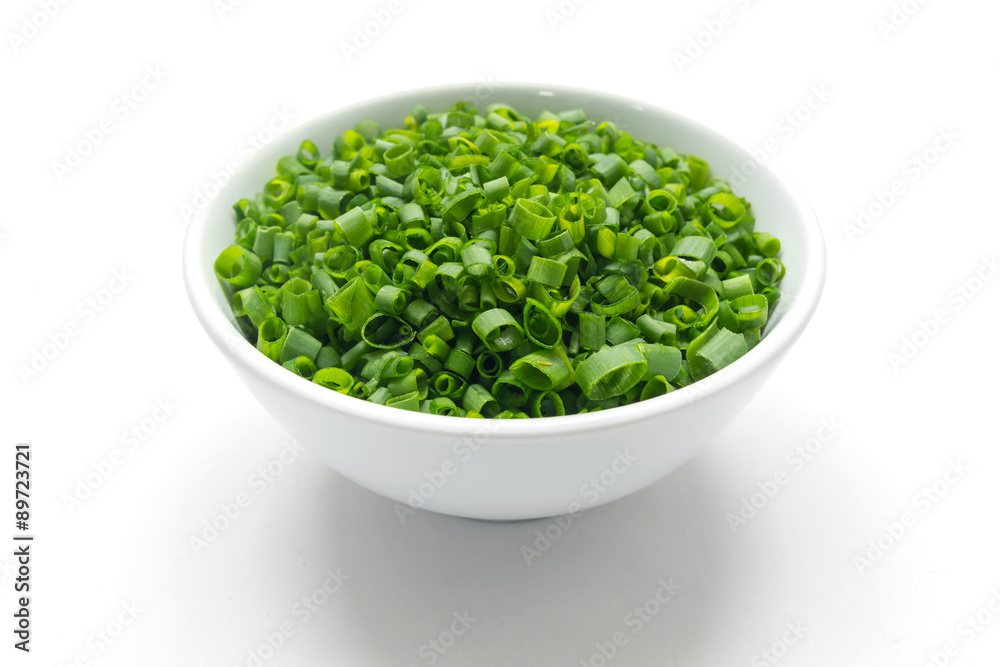 Cut tube chive leaves in white bowl, isolated background Cut tube chive leaves in white bowl, isolated background
