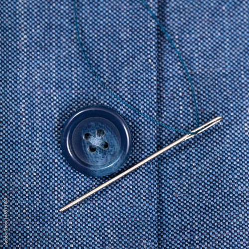 attaching of button to blue silk jacket