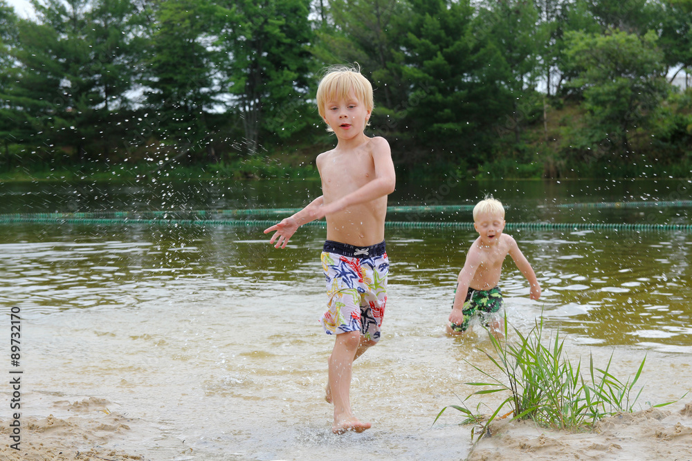 Two Young Children Swimming and Playing in Lake Two Young Children Swimming and Playing in Lake
