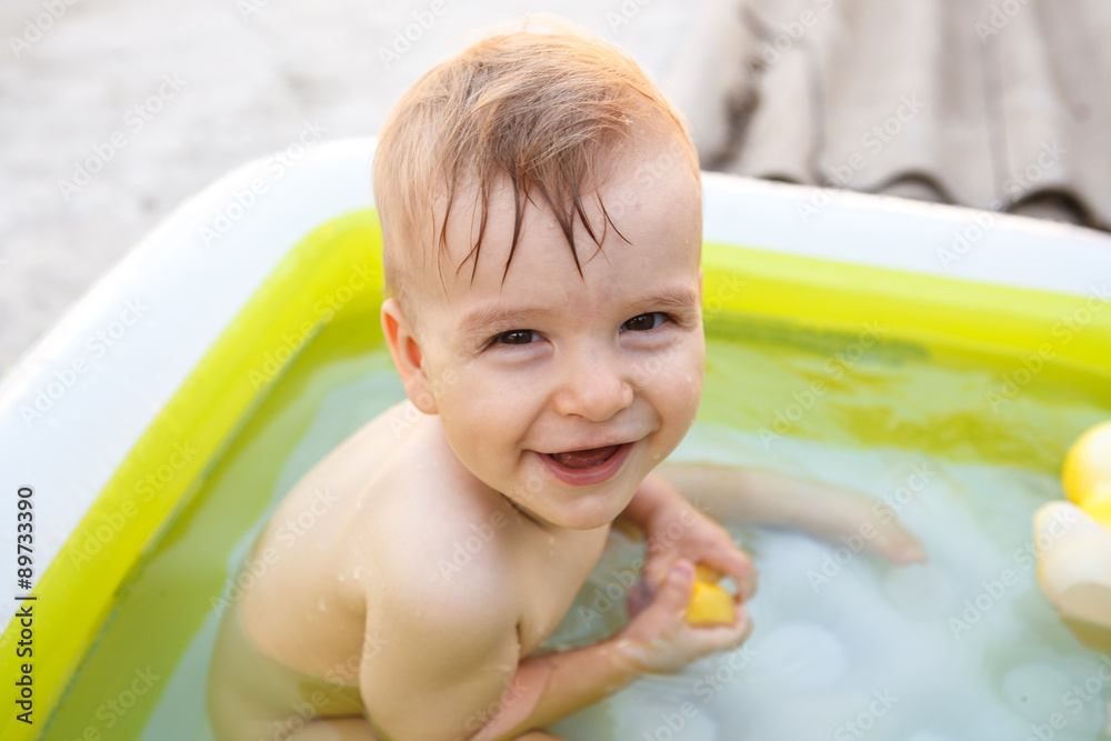 child bathes in inflatable pool outdoors, close-up portrait child bathes in inflatable pool outdoors, close-up portrait