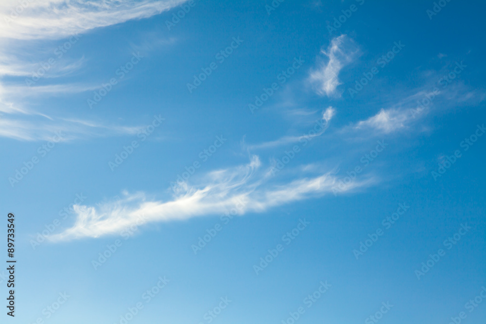 Obraz premium White cirrus clouds against a blue sky background