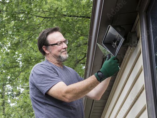 Electrician Talkng Glass Cover Off Outside Light