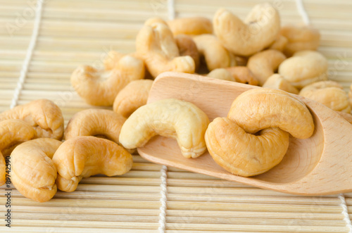 Close up cashew nuts in wooden spoon.