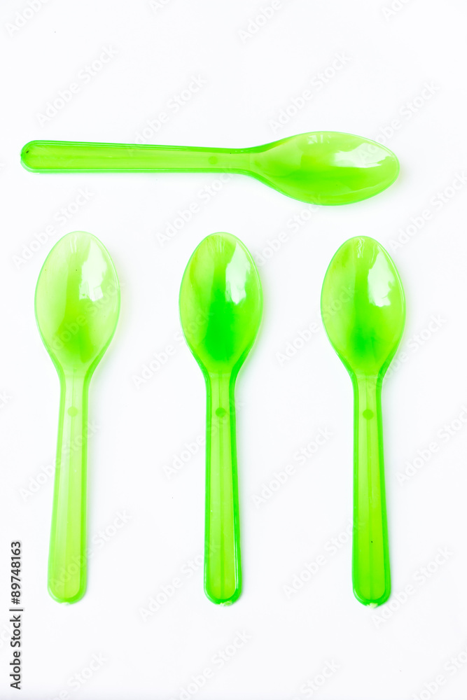 Green plastic spoon on white background