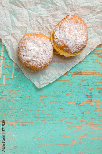 Sweet sugary donuts on rustic table