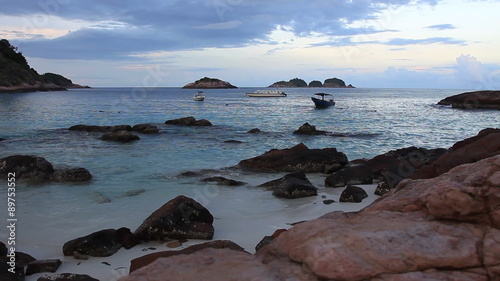 Time lapse footage of waves at shore and breaking against rocks at dusk
