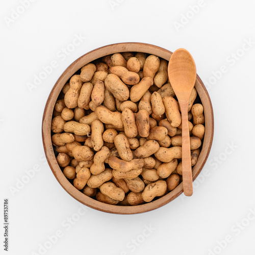 Roasted peanuts in wooden cup, top view isolated on white backgr