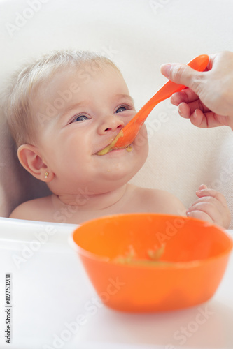 Madre dando de comer a hija puré
