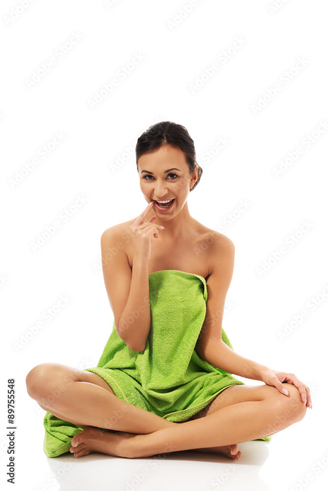Woman sitting cross-legged wrapped in towel Woman sitting cross-legged wrapped in towel