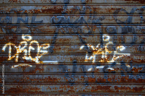 Rusty steel garage door with graffiti