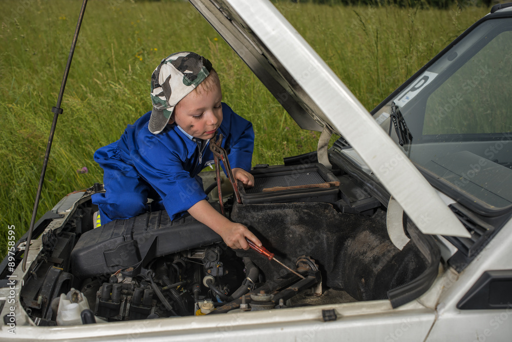 Meccanico bambino al lavoro su motore auto