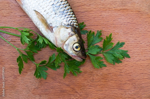 fish and parsley leaves on a board