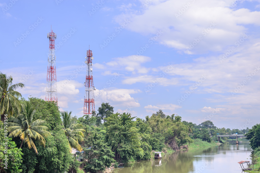 Obraz premium Mobile telephone antenna near river.