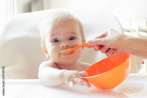 Bebé hermoso comiendo puré photo