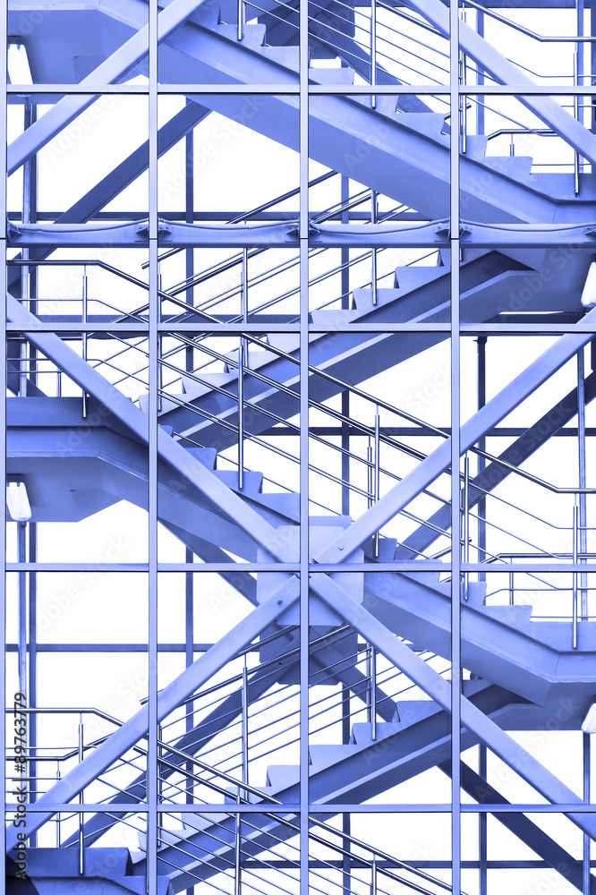 Modern business office stairs with steel handrail in new building with transparent glass walls, architectural geometric abstraction in blue tone Modern business office stairs with steel handrail in new building with transparent glass walls, architectural geometric abstraction in blue tone