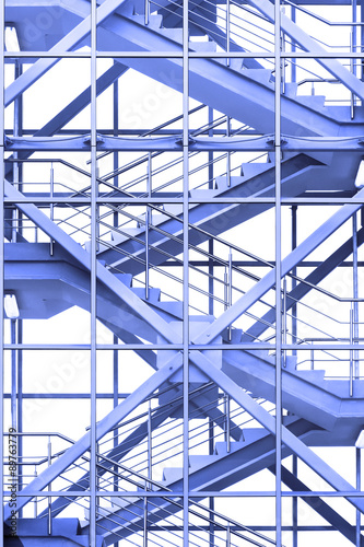 Modern business office stairs with steel handrail in new building with transparent glass walls, architectural geometric abstraction in blue tone 