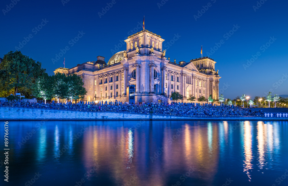 Illuminated Reichstag building with Spree river at dusk, Berlin, Germany