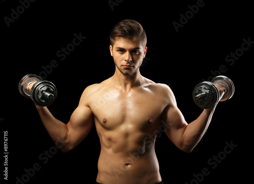 Muscle young man holding du...