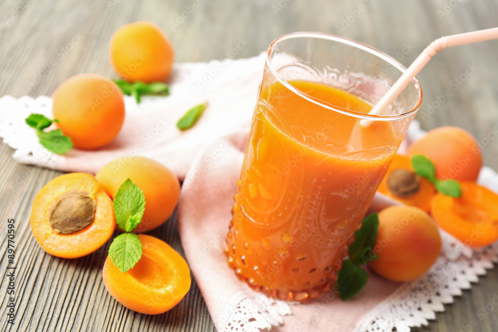 Glass of apricot juice and fresh fruits on table close up Glass of apricot juice and fresh fruits on table close up