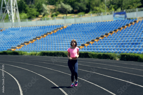 Young woman jogging on stadium © Africa Studio