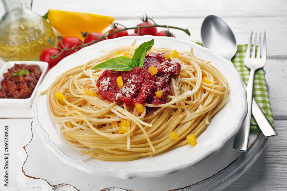 Spaghetti with tomato sauce and cheese on white plate, on color wooden background Spaghetti with tomato sauce and cheese on white plate, on color wooden background