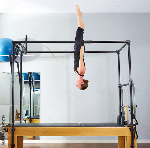 Fototapeta Pilates woman in cadillac acrobatic upside down