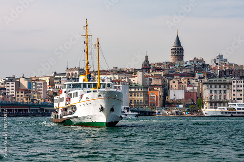 Panorama of Istanbul and the Bosporus with the ship in the foreground. Turkey. The photo Galata Tower and the bridge, passenger ship closeup. The evening of a sunny day.