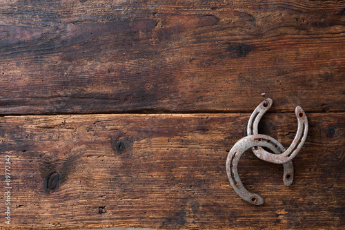 Two old rusty horseshoe on vintage wooden board